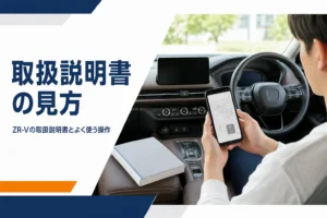 車内でスマホと冊子の取扱説明書を見比べる手元